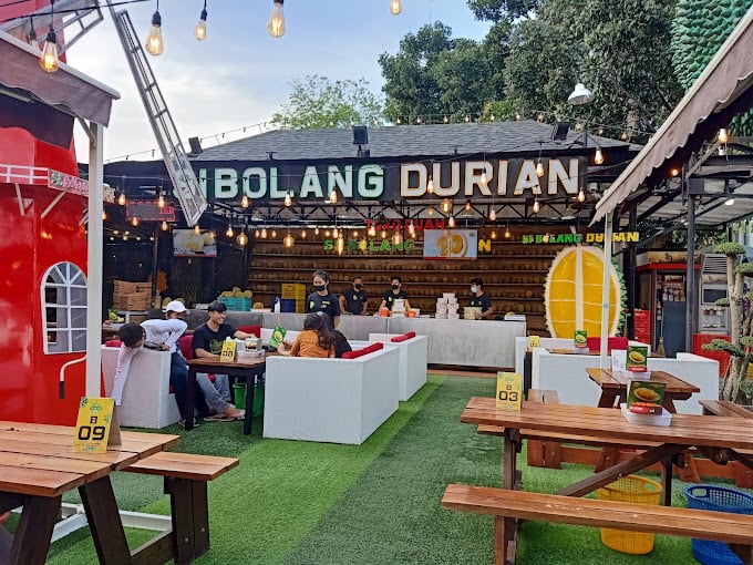 A group of people sitting at tables outsideDescription automatically generated