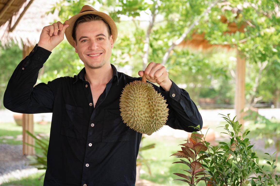 A person holding a durianDescription automatically generated