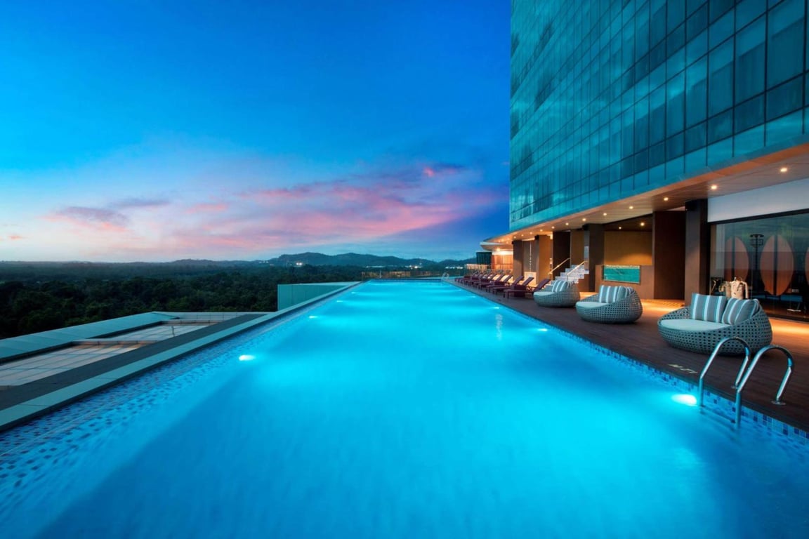 A pool with chairs on top of a buildingDescription automatically generated