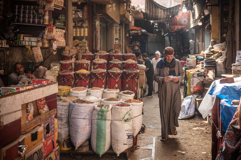 A Male Walking Through A Busy Bazaar