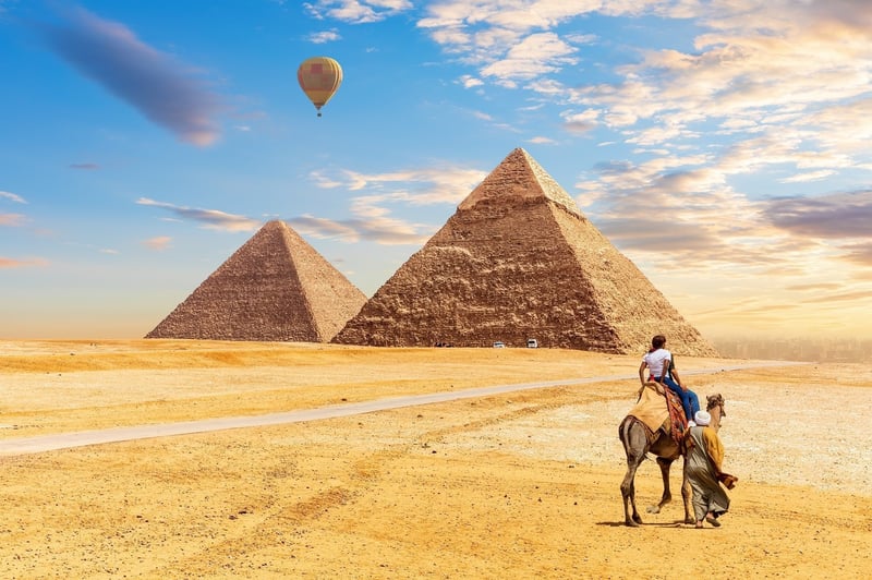 Tourist On Camel In Front Of The Pyramids Of Giza