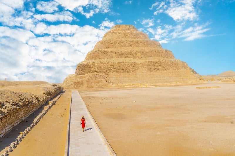 A Young Tourist In A Red Dress In Front Of Saqqara