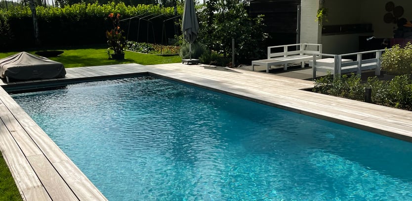 zwembad met houten terras en helder blauw water