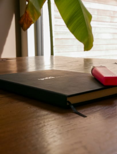 yuki notitieboek met roze markeerstift op houten tafel