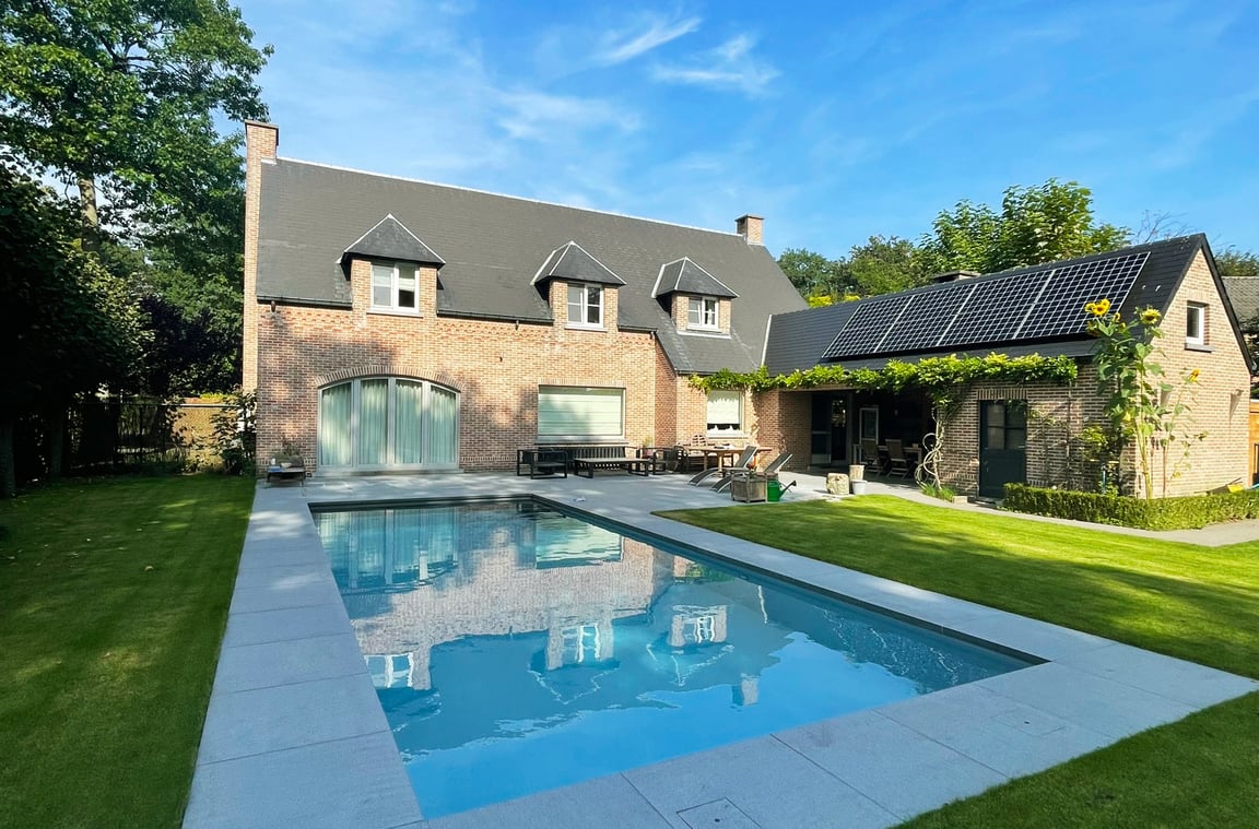 zwembad bij woning met zonnepanelen