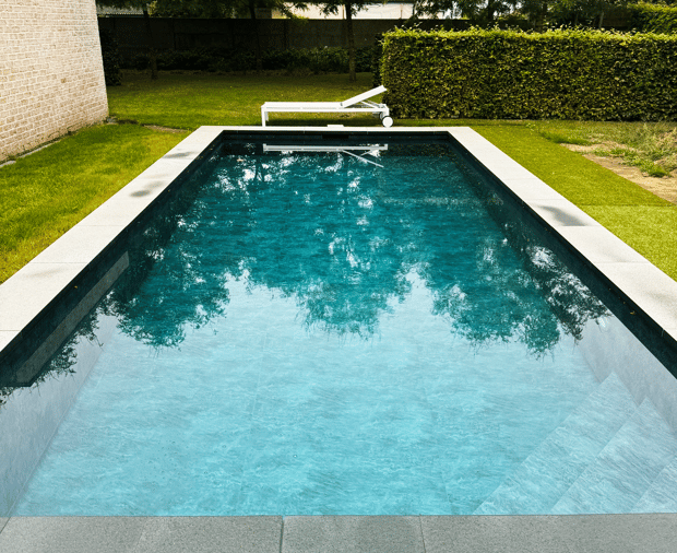 strak zwembad met natuursteen afwerking