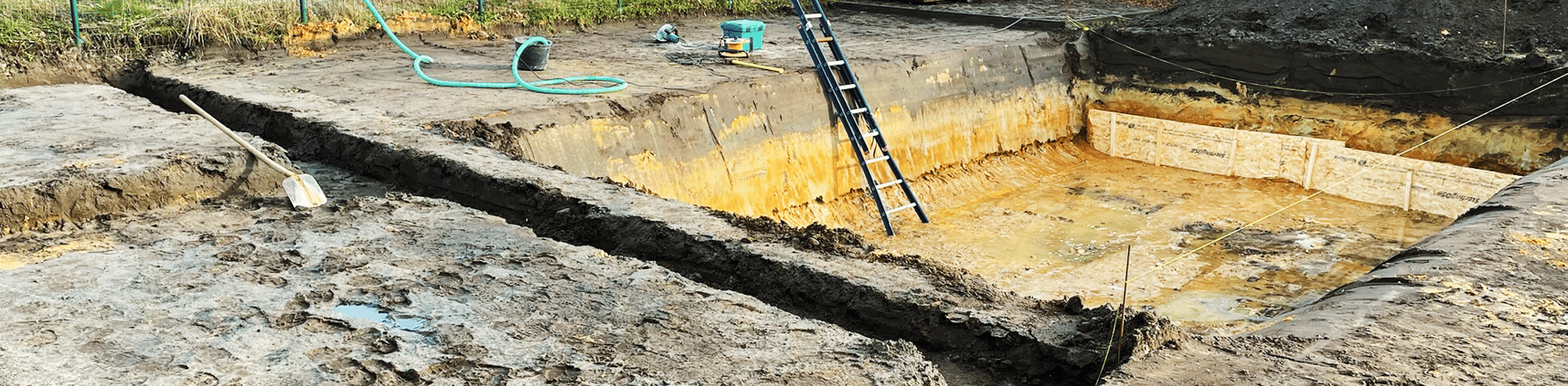 bouwput met ladder tijdens graafwerken zwembad