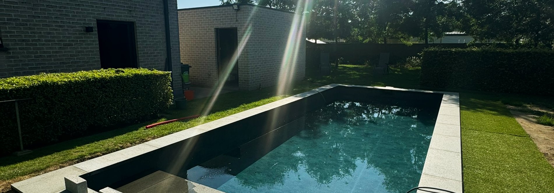 zwembad met stralende zon en natuurstenen afwerking