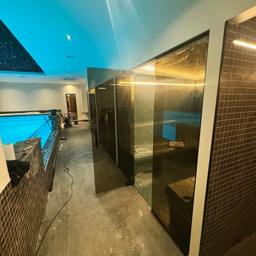 luxe indoor zwembad met glazen sauna en moderne verlichting