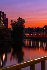 Sunset over a river with reflections and city lights