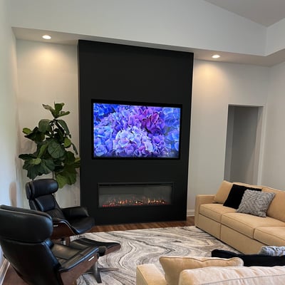 the great room featuring flat screen tv above fireplace surrounded by comfortable chairs and sofas