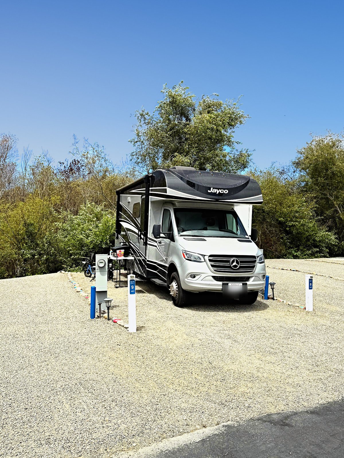 A Class C motorhome on Site 8 with painted rocks along the site edge at Beach RV Pleasure Point.