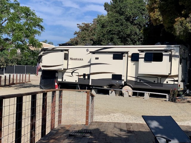 A fifth-wheel RV parked at the private owner's spot beside Beach RV Pleasure Point