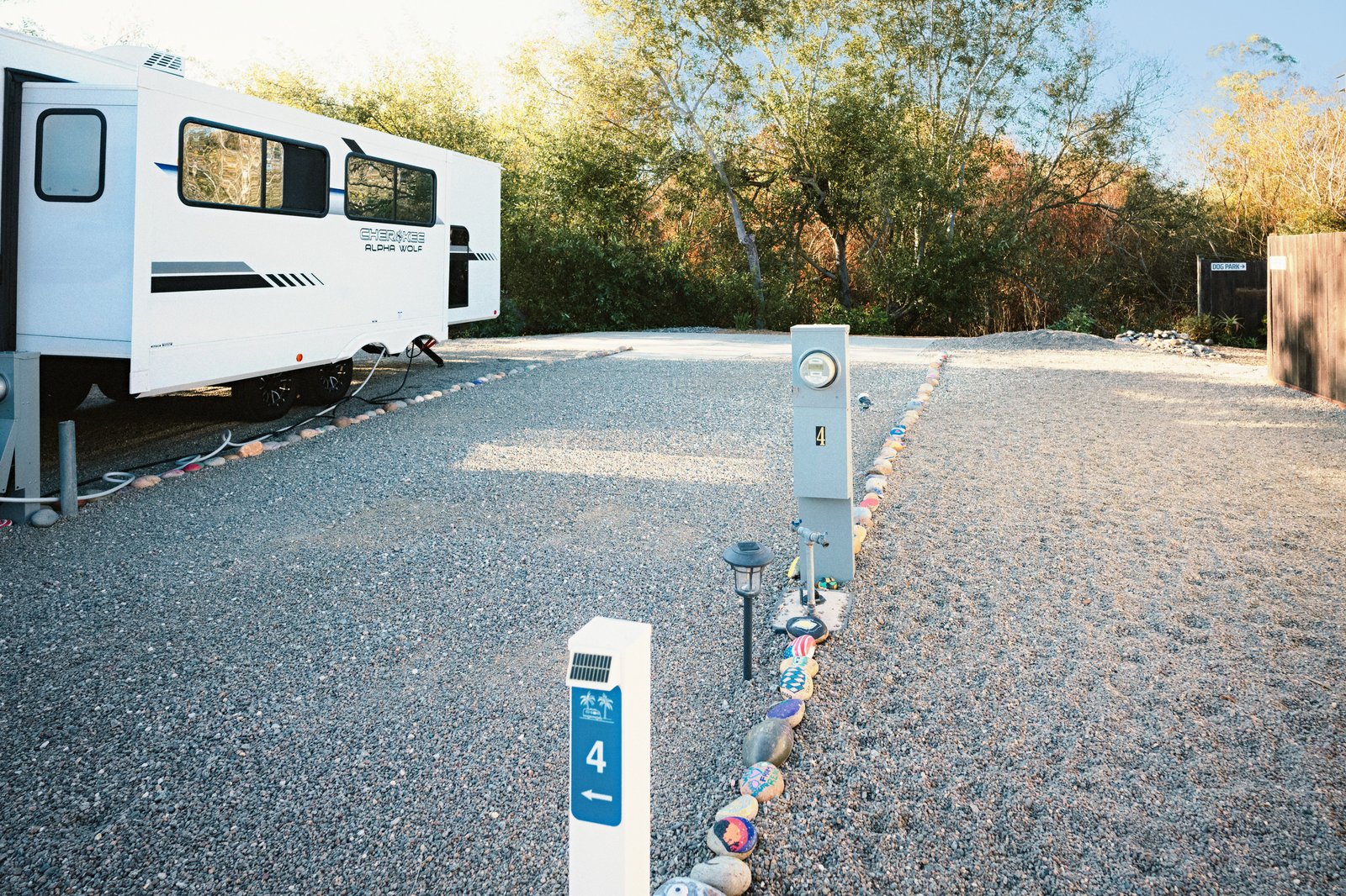 Site 4 hookup pedestal and painted-rock boundary beside a trailer at Beach RV Pleasure Point.