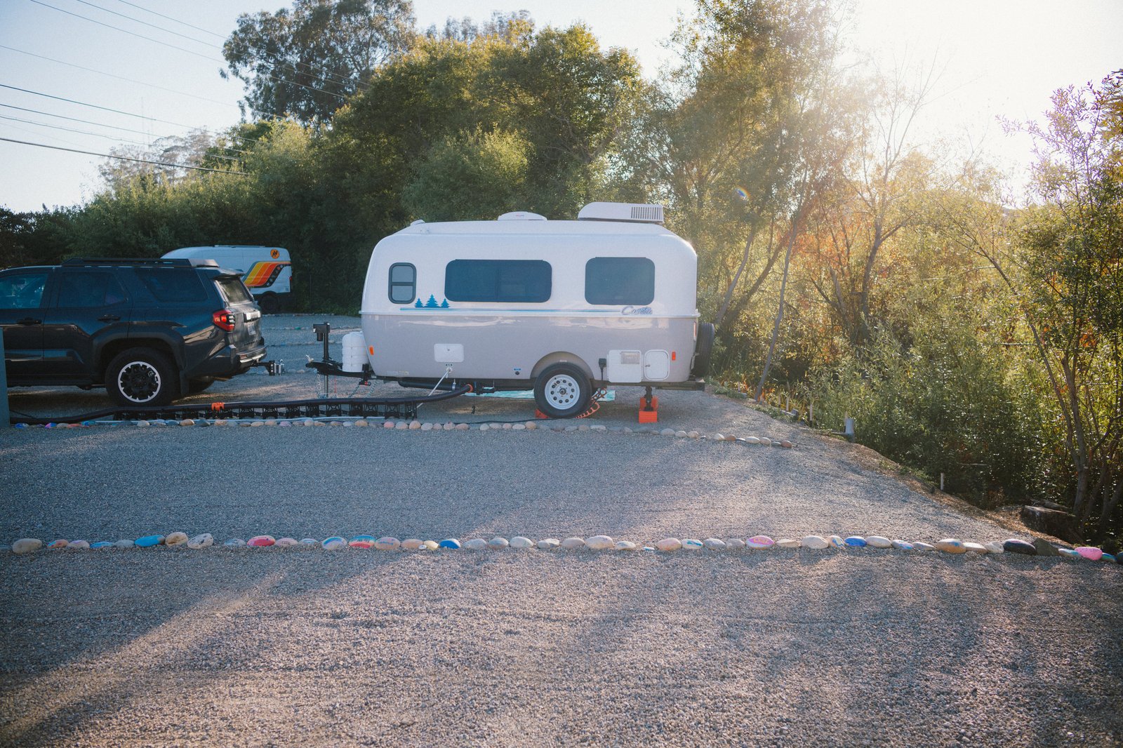 A Casita travel trailer and tow vehicle parked beneath trees at Beach RV Pleasure Point.