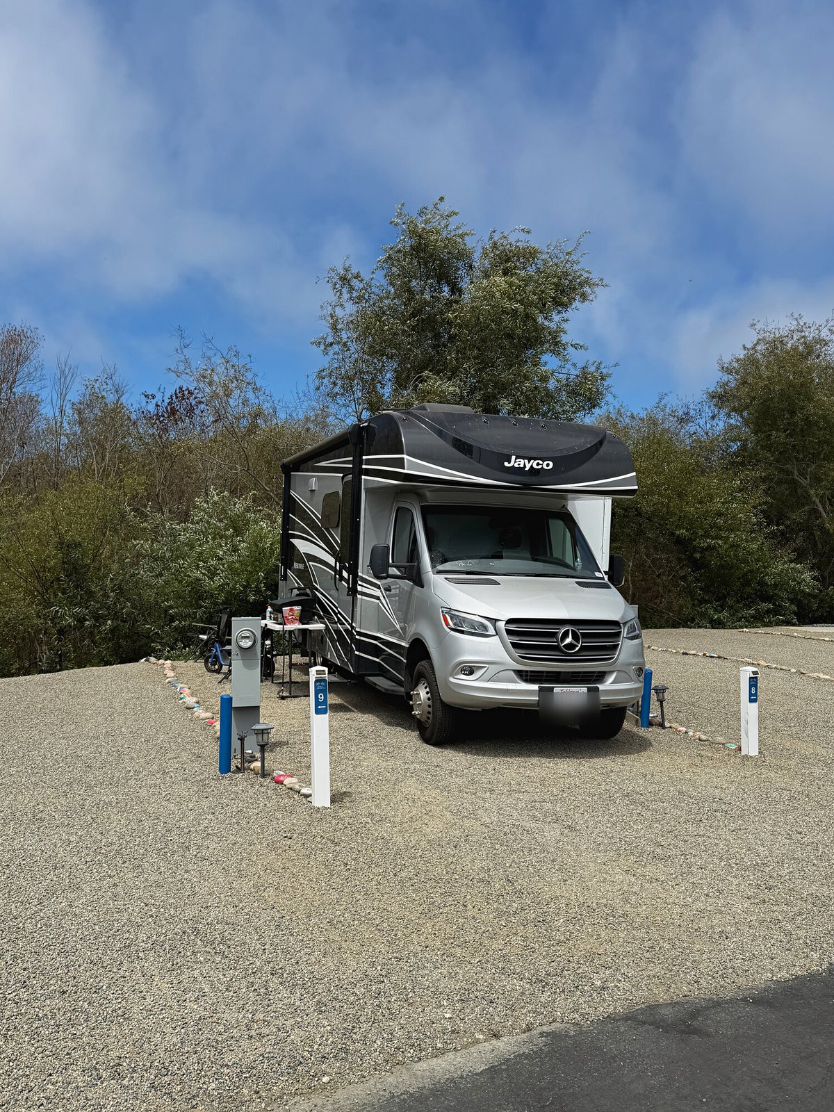 A Class C motorhome on Site 8 with painted rocks along the site edge at Beach RV Pleasure Point.