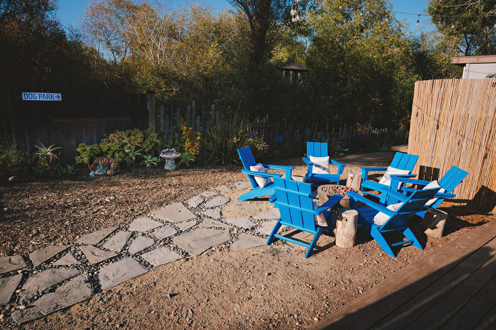 Blue Adirondack chairs around the fire pit patio at Beach RV Pleasure Point