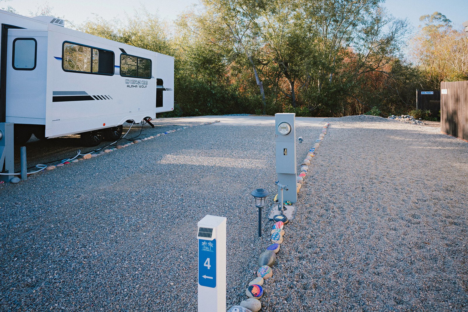 Full-hookup pedestal and painted rock border on Longboard site 4, a 60-foot big-rig pad at Beach RV Pleasure Point