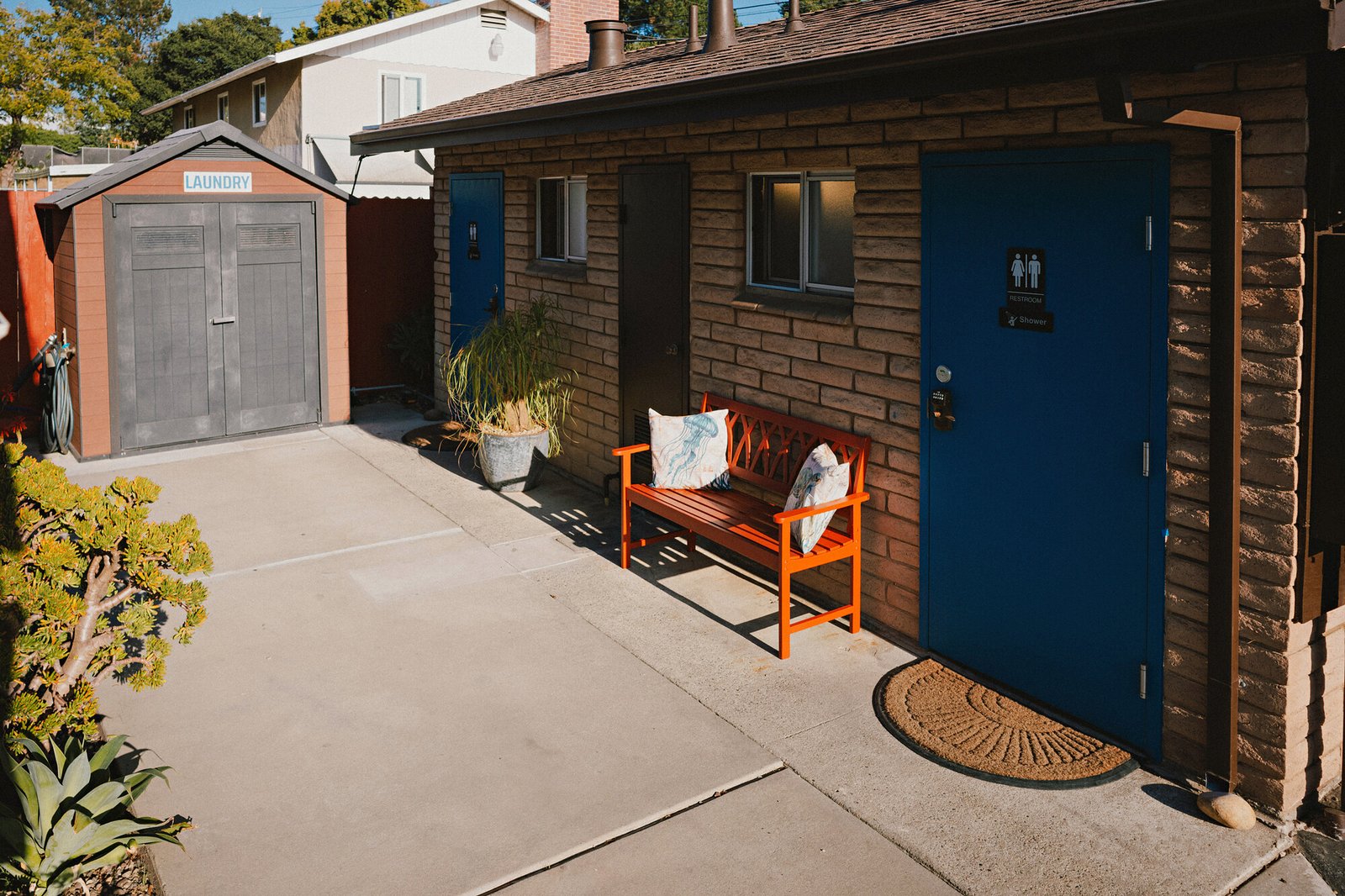 Bathhouse entrance with blue door and orange bench at Beach RV Pleasure Point