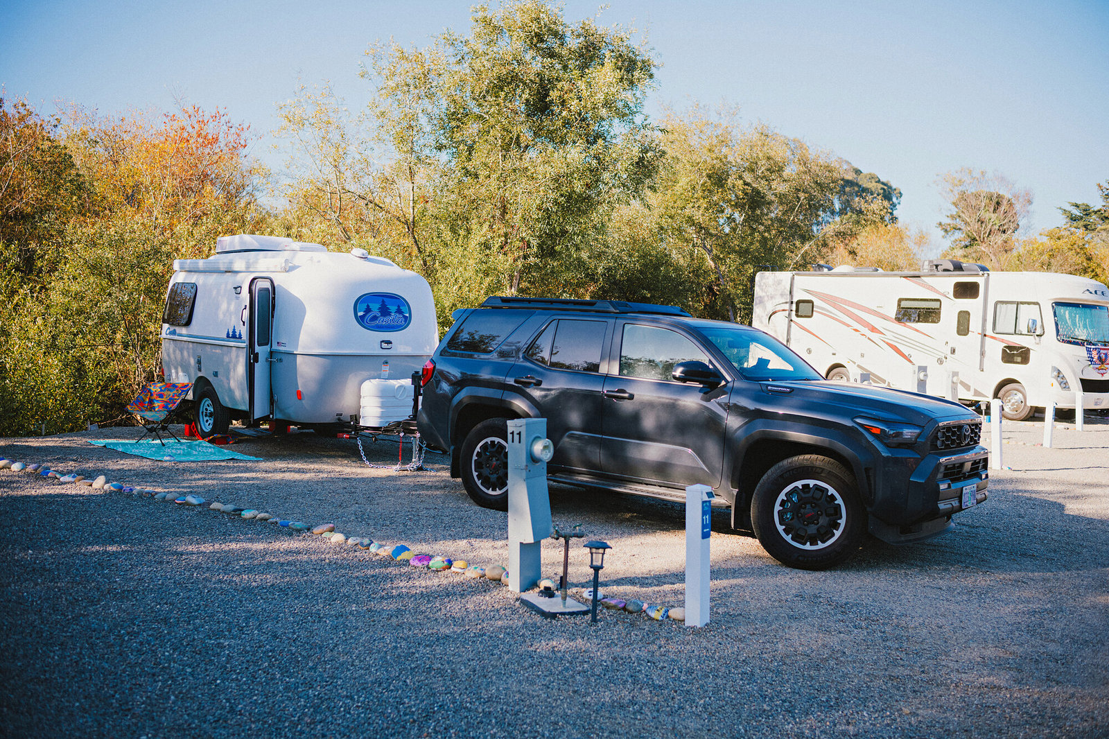 Casita travel trailer and SUV on a Standard Plus site under autumn trees