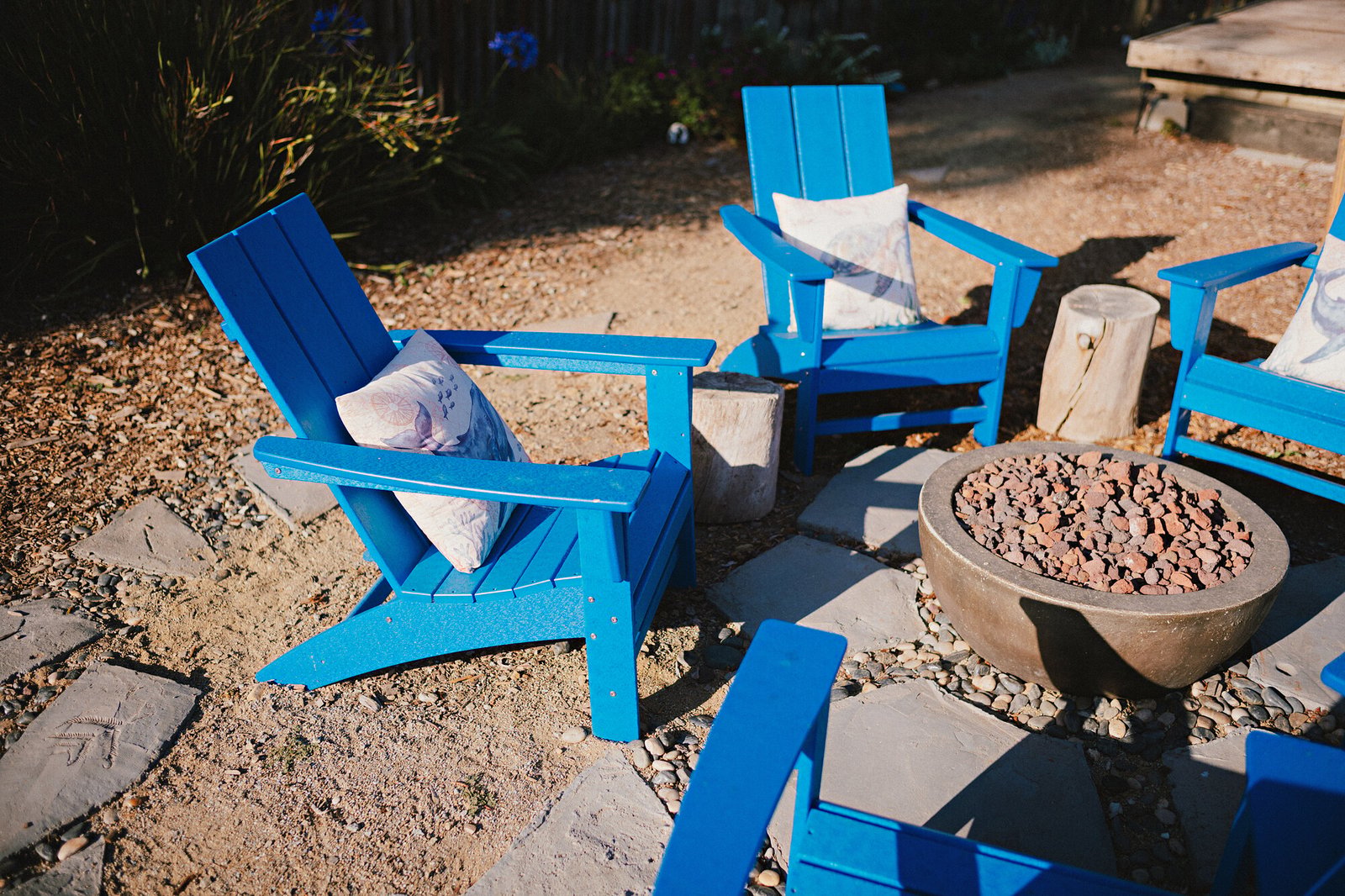 Blue Adirondack chairs and a fire bowl in the park's fire pit area