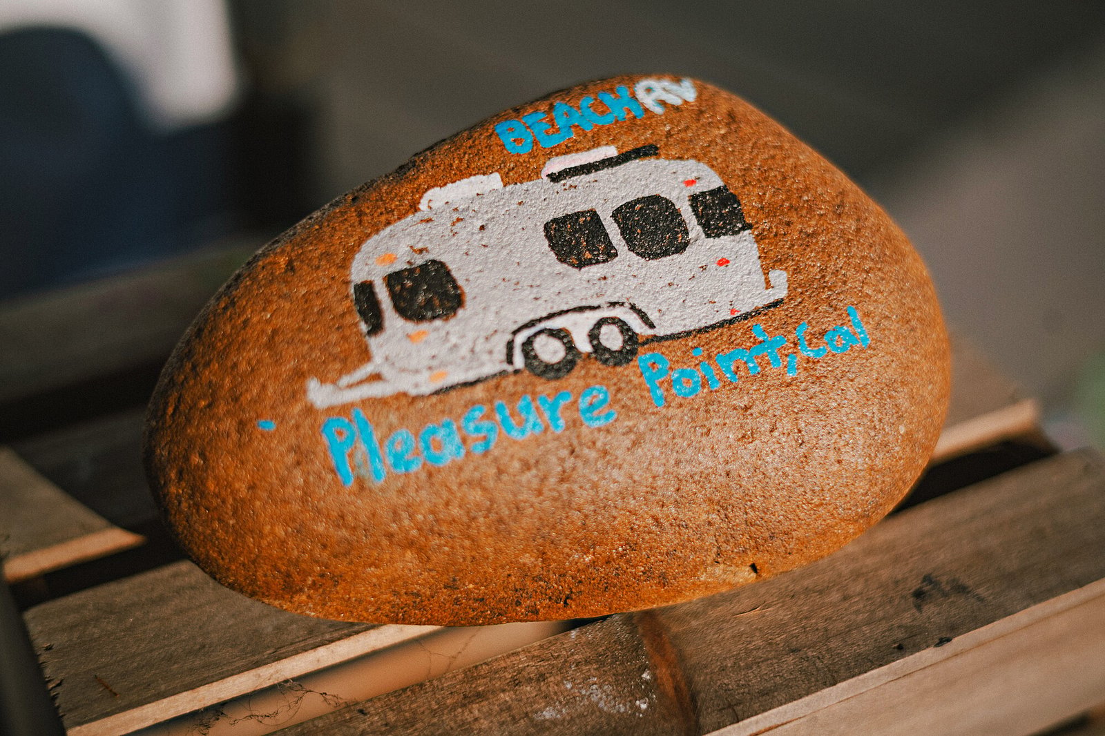 Painted rock with an Airstream and 'Pleasure Point' lettering, made by a guest