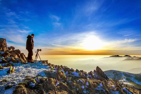 professional-photographer-takes-photos-with-camera-tripod-rocky-peak-sunset (1) (1)