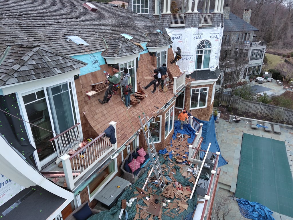 Crews working on a cedar shake roof