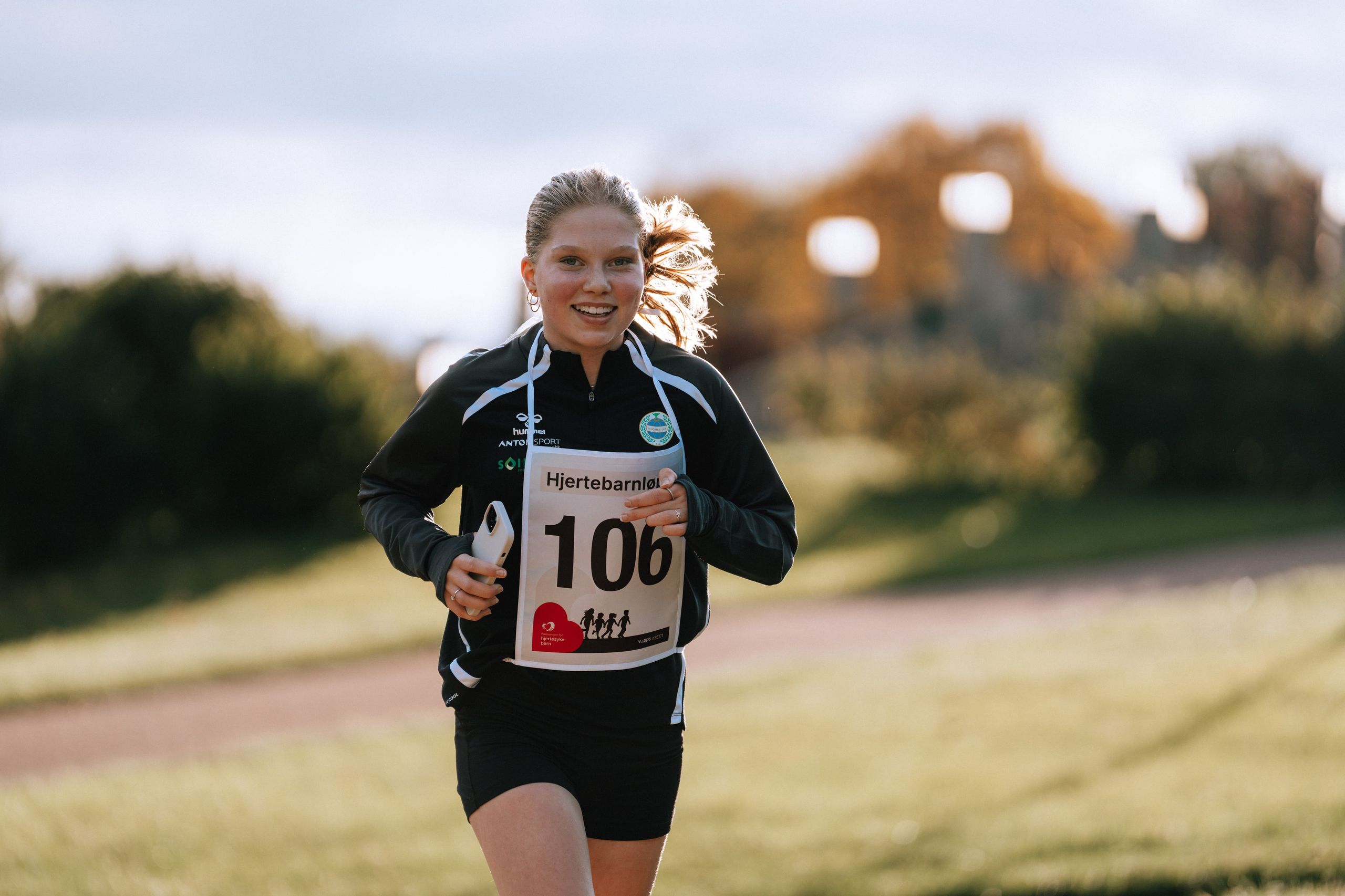 Smilende løper med startnummer i Hjertebarnløpet