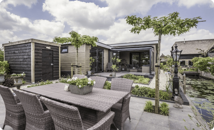 Tuinwoning met terras en vijver in een groene tuin