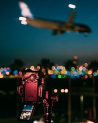 black video camera capturing an airplane in flight