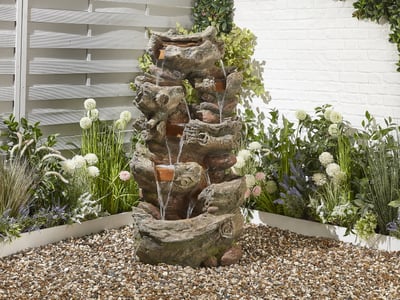 Highland cascading garden waterfall with tall stacked stone in a rural UK garden
