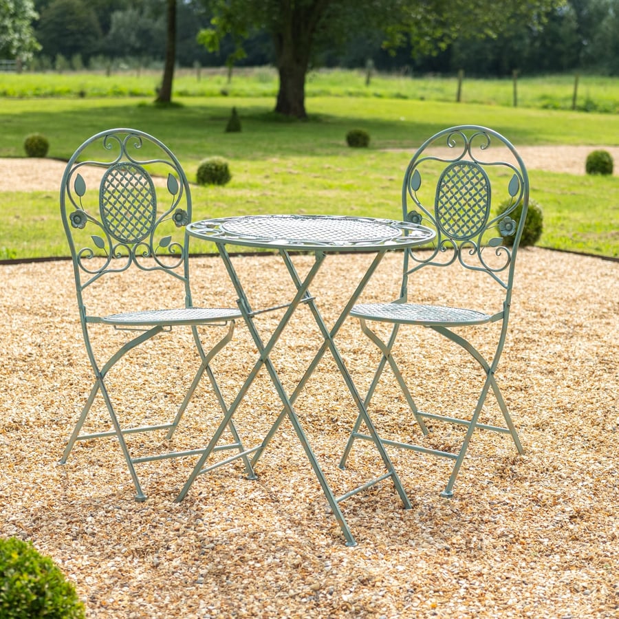Yoxford vintage green metal bistro set folded on a UK terrace courtyard with climbing roses