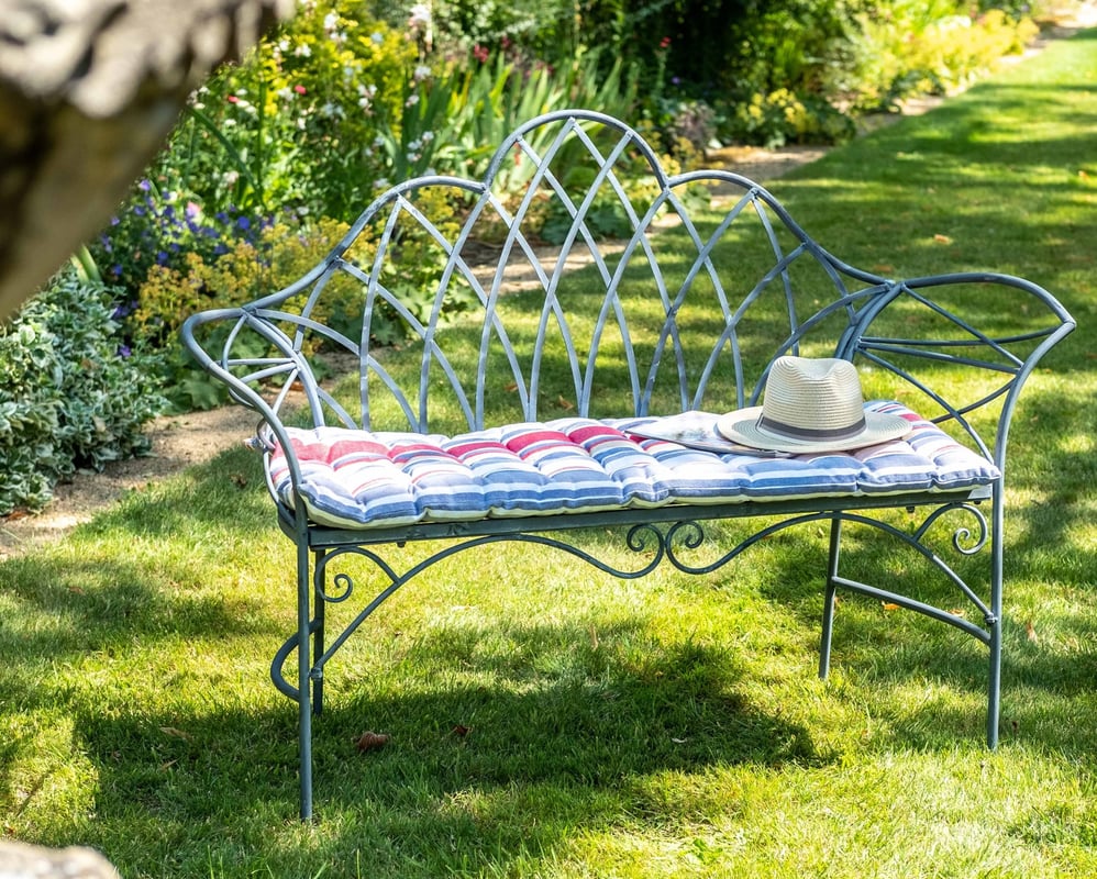 Mayfair lead grey metal garden bench in a country garden setting