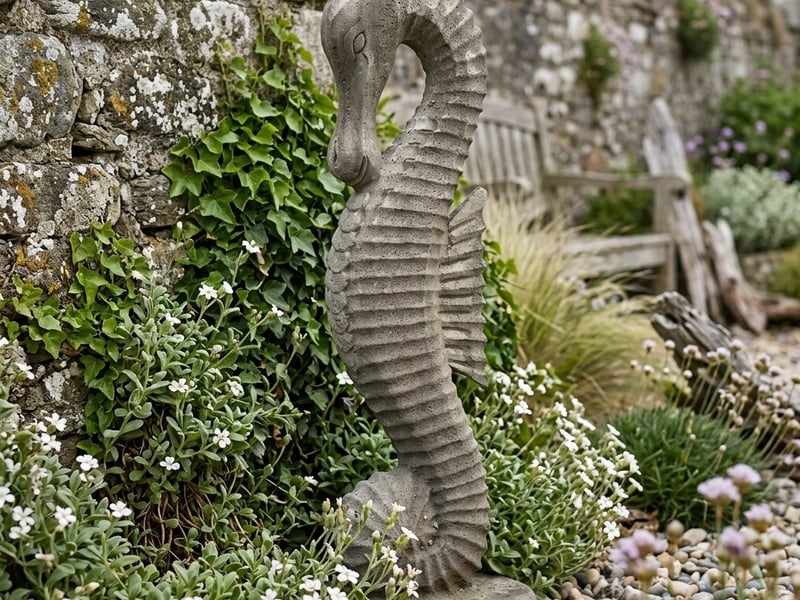 Stone Seahorse Statue in aged Cotswold finish beside a coastal garden wall - coastal garden ornaments uk