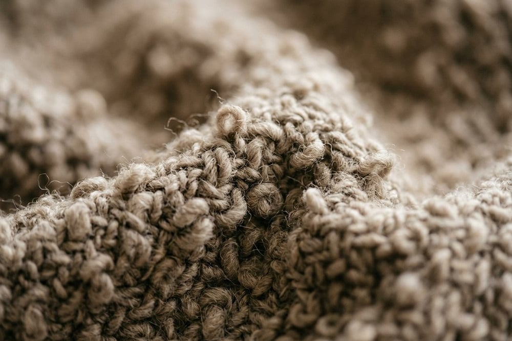 Close-up of mushroom-toned boucle fabric showing its looped weave