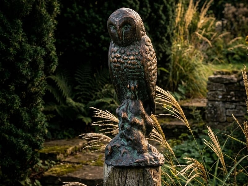 Garden ornament trends 2026 dark metal finish Barn Owl ornament with bronzed patina in a UK garden border