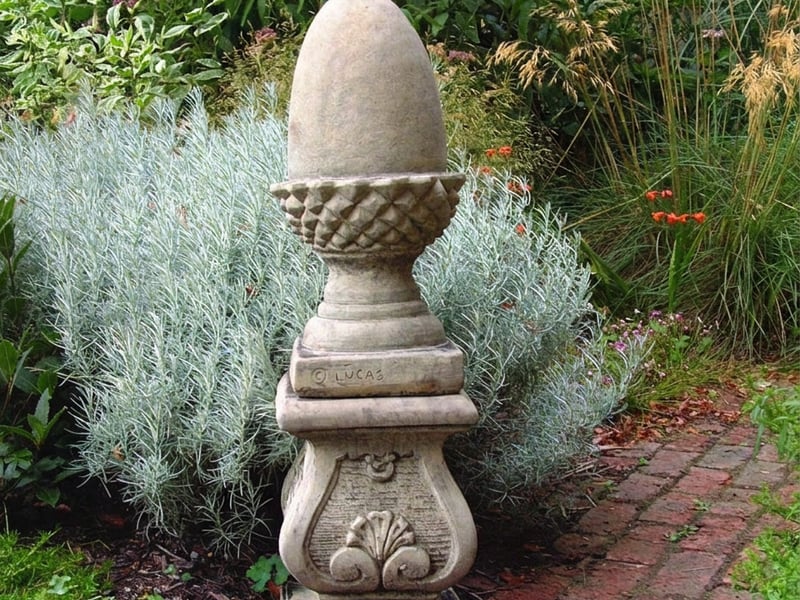 Scroll Plinth stone garden pedestal in a cottage garden setting with roses