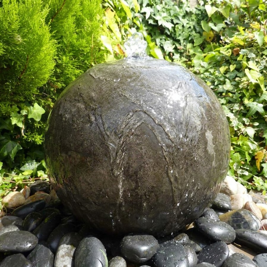 Black polished limestone sphere water feature in a contemporary Japanese-style UK garden