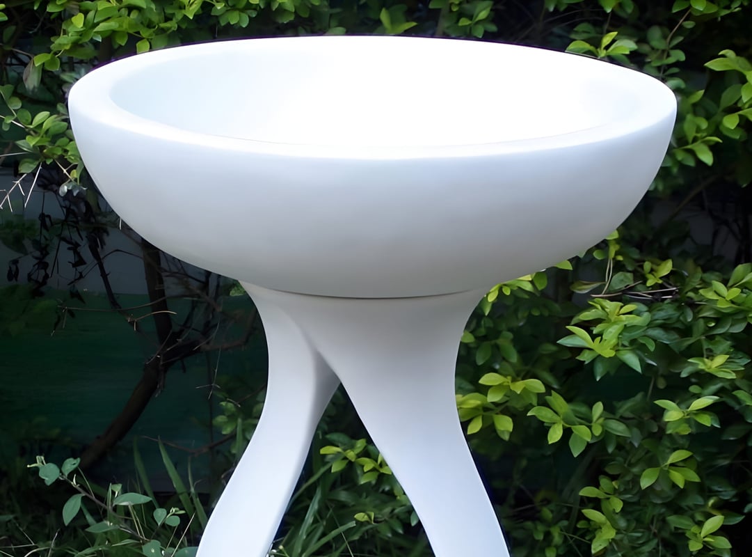 Contemporary white polystone bird bath with minimalist column in a UK modern garden