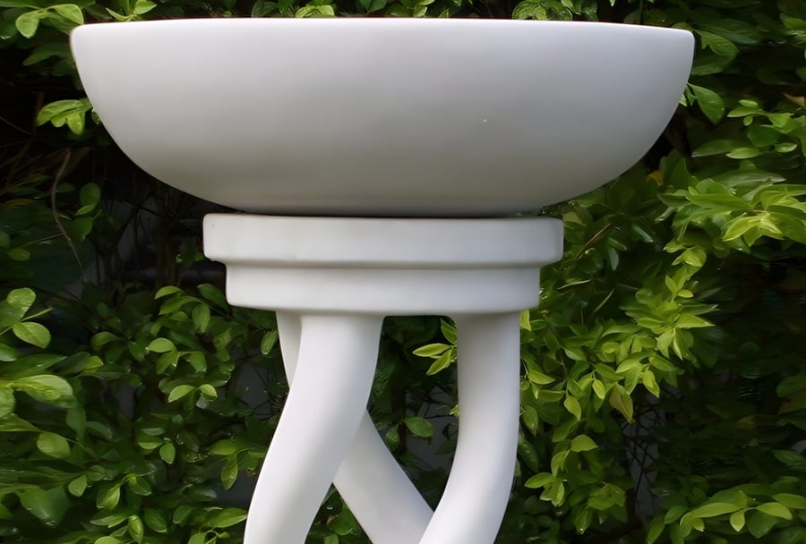 Spiral Bird Bath in White pedestal style positioned 4m from shrubs in a UK garden