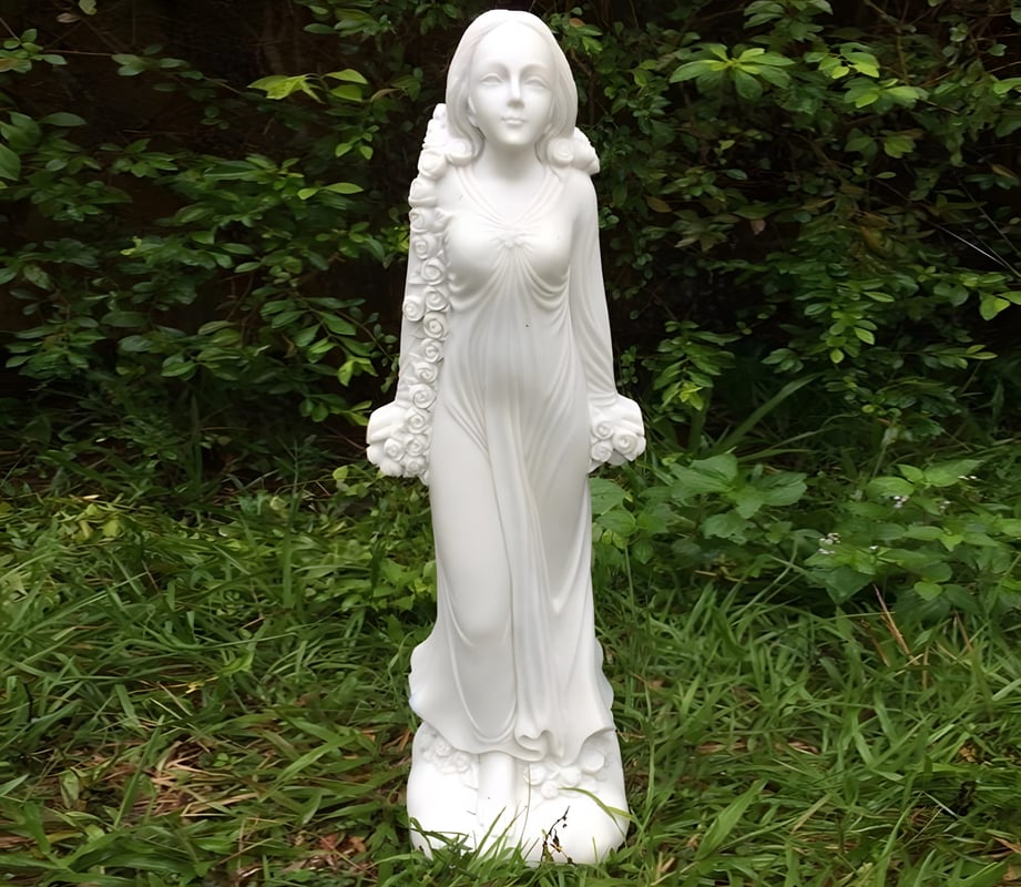 Flora mythological garden statue UK Roman goddess of flowers in a cottage garden border