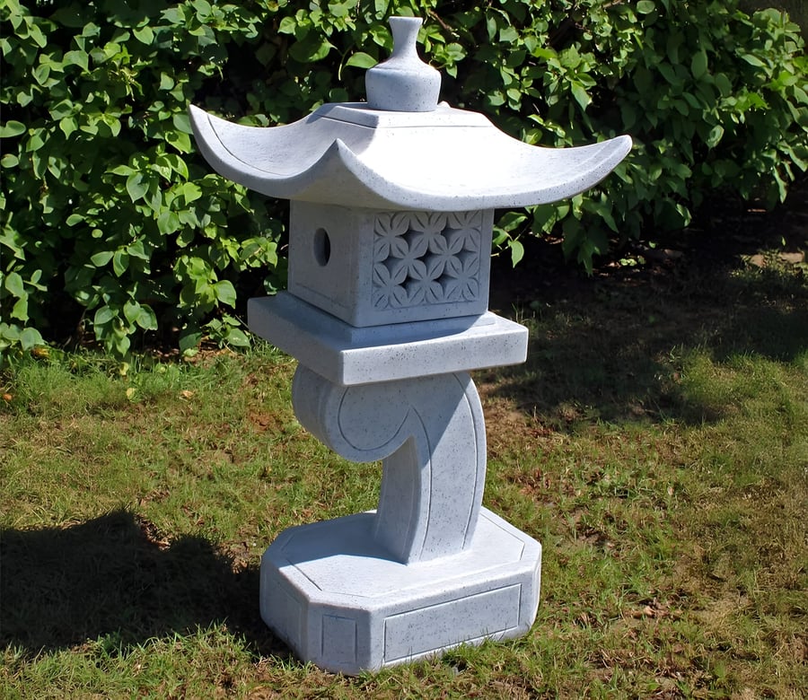 Granite oriental lantern toro placed next to a stone water basin in a UK Japanese garden