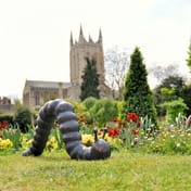 Large Caterpillar Metal Garden Ornament in Bronze Patina on Lawn