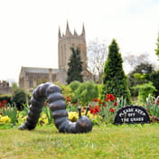 Large Caterpillar Metal Ornament Displayed in a Garden Setting