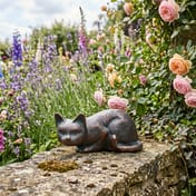 Lying Cat Metal Garden Ornament on stone wall in cottage garden