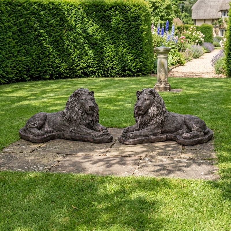 Chatsworth stone lion statues pair flanking a garden entrance with ornamental metal gate