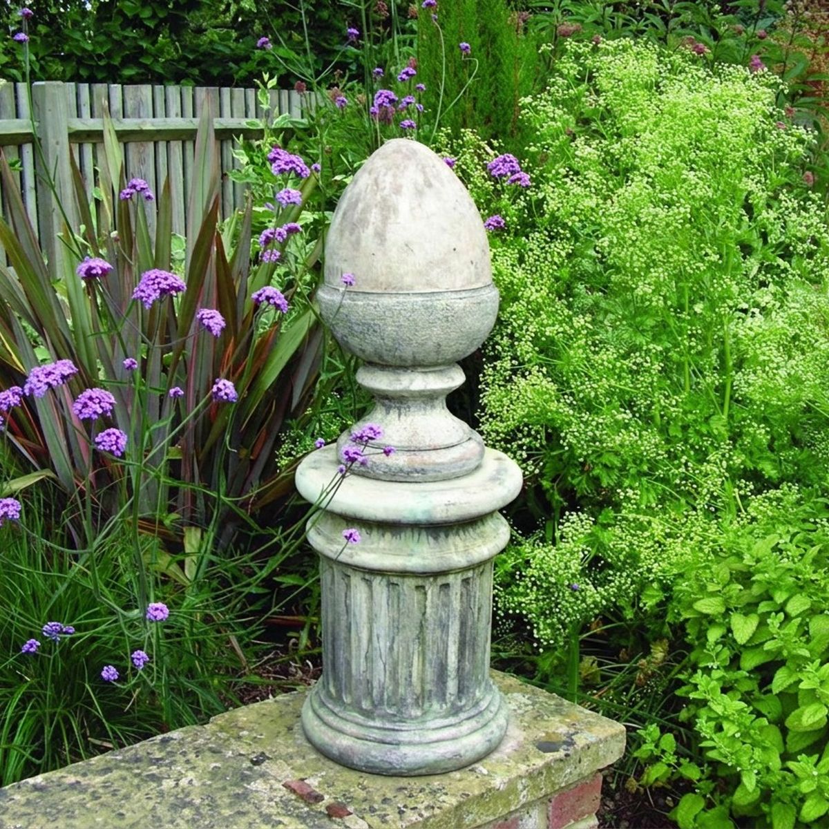 Keymer Acorn Stone Garden Finial on a brick pillar in a UK garden