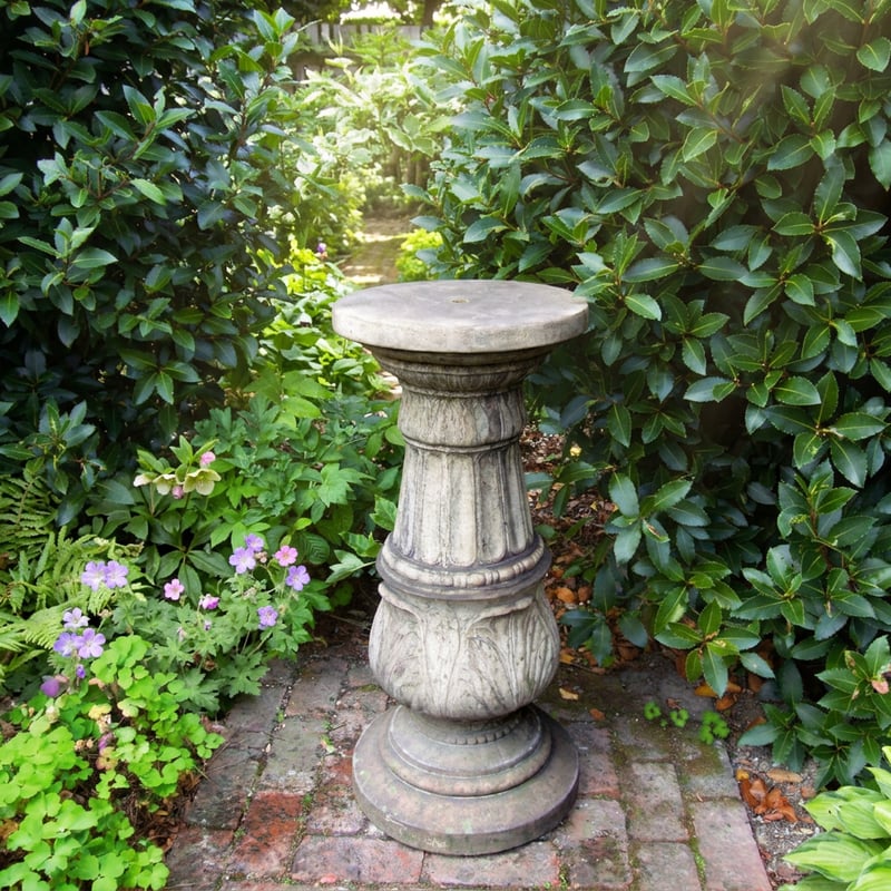 Large stone garden pedestal in Cotswold finish in a country garden setting