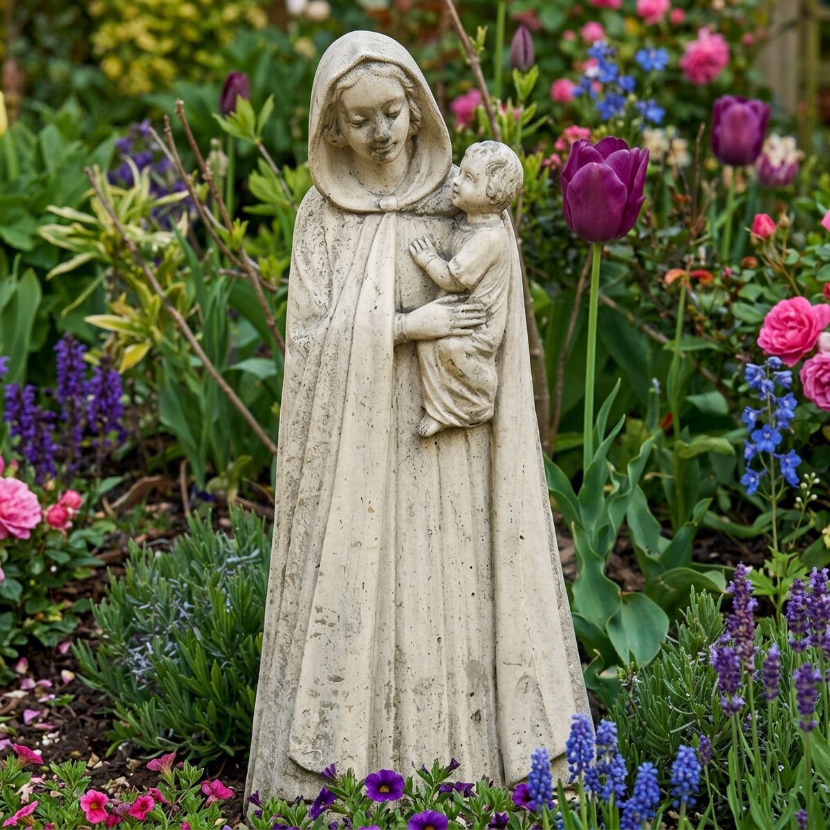 Madonna and Child stone garden statue displayed in a garden border setting